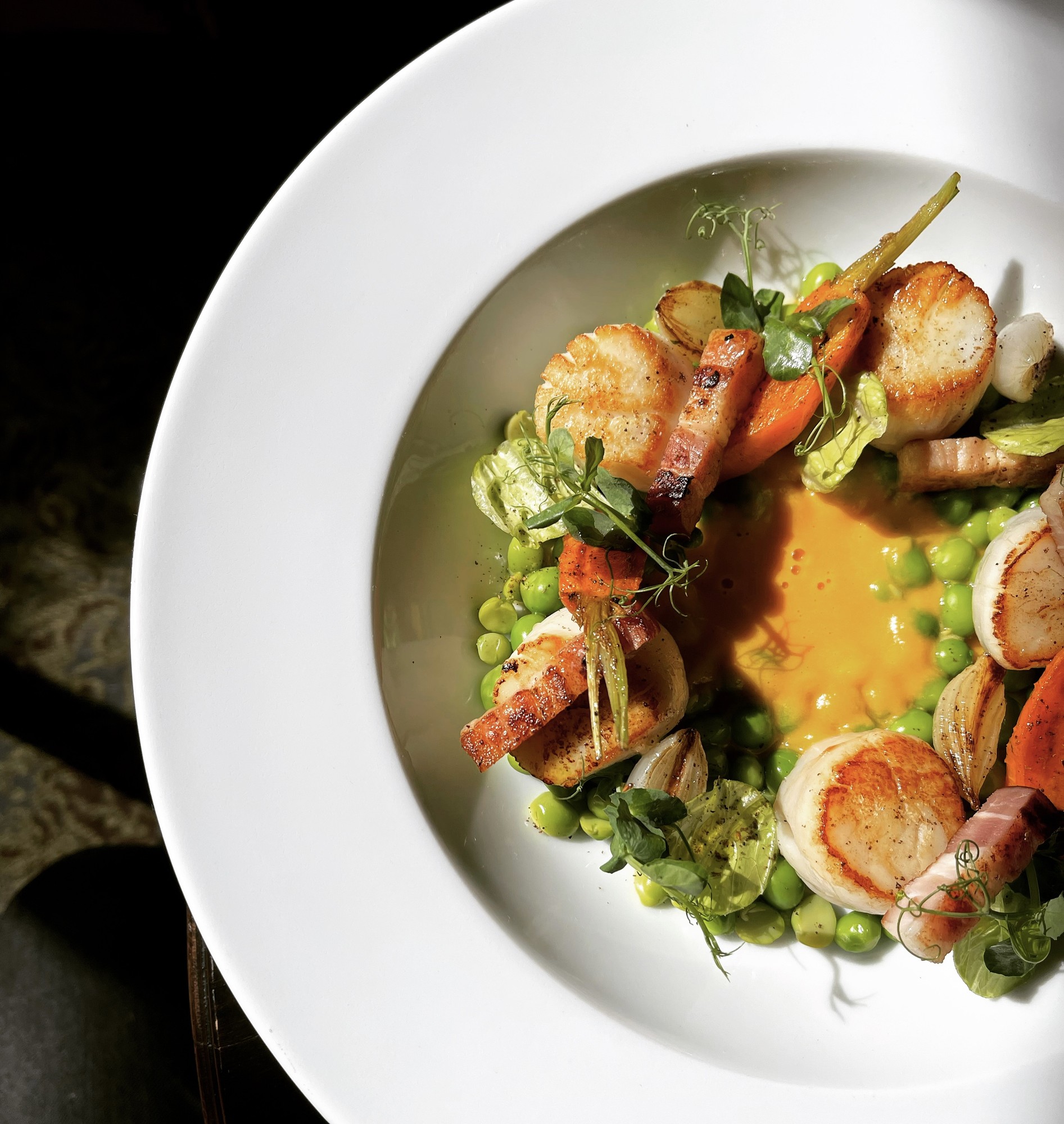 Seared scallops with peas, bacon and carrot