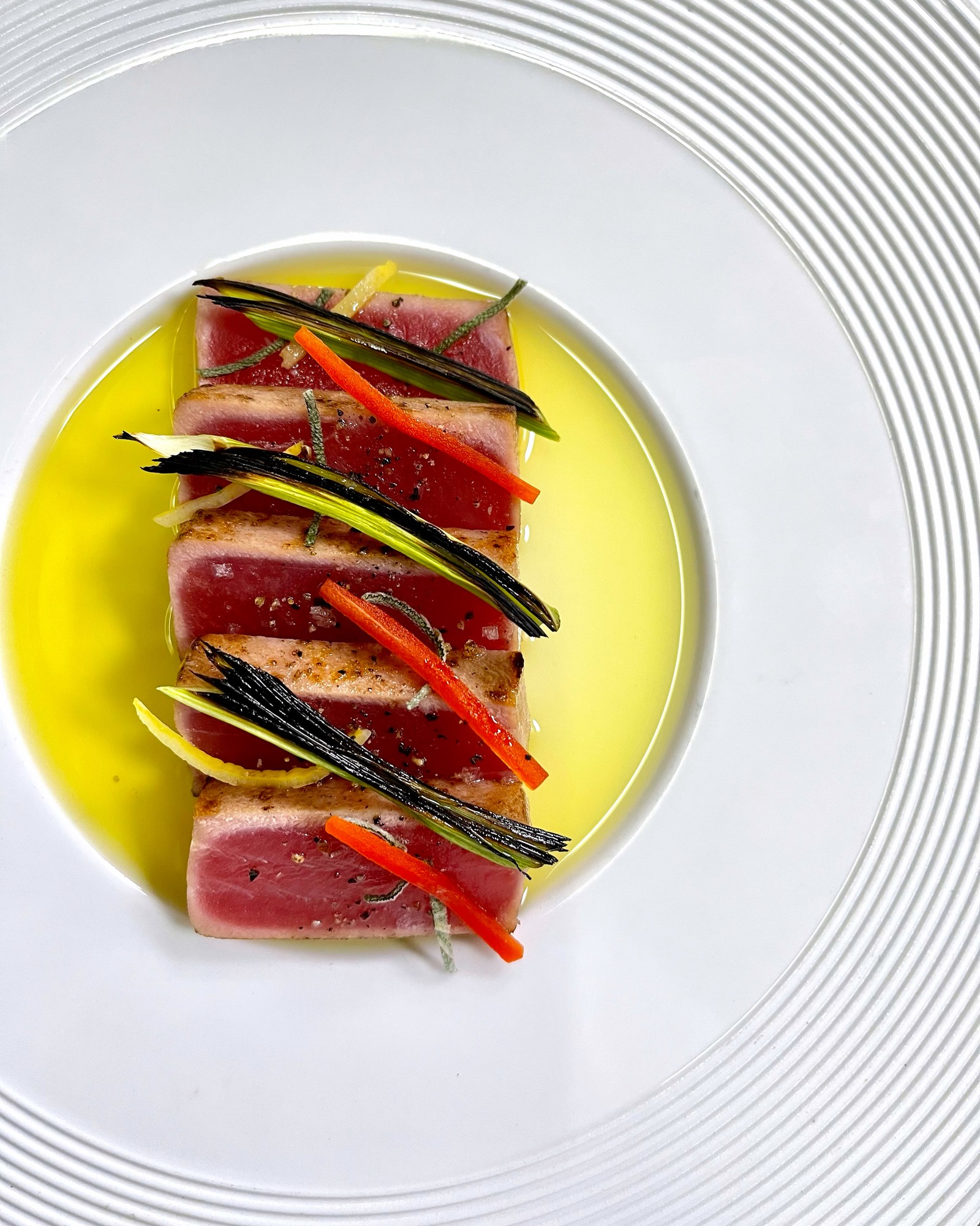 Seared tuna sliced over olive oil with charred scallion and carrot